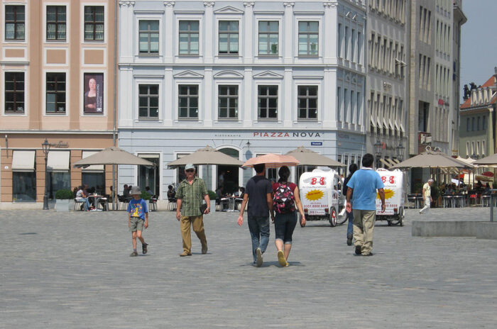 Menschen laufen bei Sommerhitze mit Sonnenschirmen über den versiegelten Neumarkt in Dresden. Menschen laufen bei Sommerhitze mit Sonnenschirmen über den versiegelten Neumarkt in Dresden.
