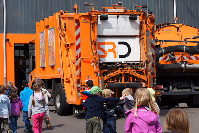 Kinder vor einem Müllauto auf dem Gelände der Stadtreinigung Dresden