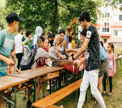 Junge Menschen stehen an einem Tisch bei einem Fest