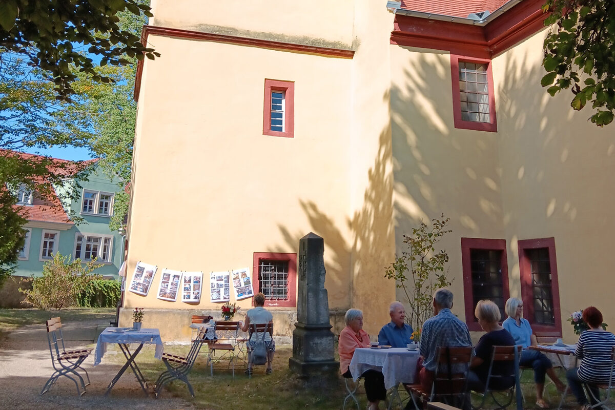 Kaffeetrinkende Besucher vor der Pastor-Roller-Kirche