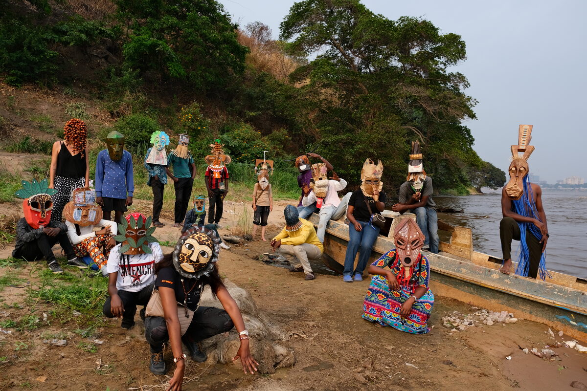 Menschengruppe mit Masken am Fluss