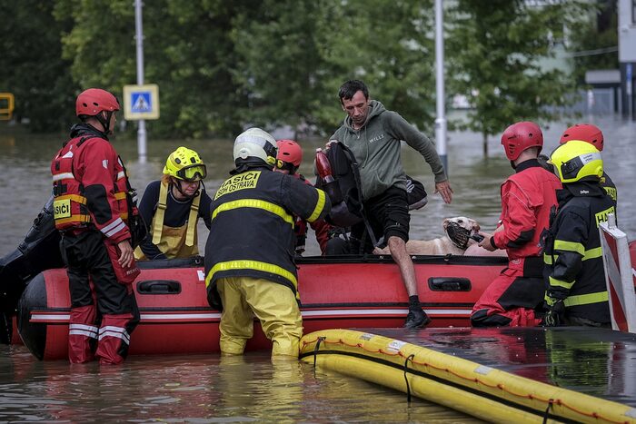 Feuerleute helfen Evakuierten aus dem Sclauchboot, Straße überflutet