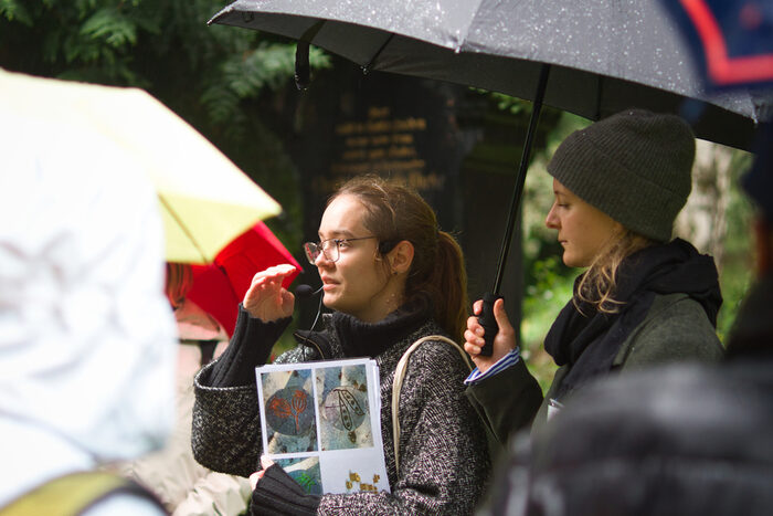 Frau Müller, Prugger Landschaftsarchitekten, erläutert die Freiraumplanung. Sie hat Planunterlagen in der Hand, neben ihr eine Frau, die den Regenschirm hält.