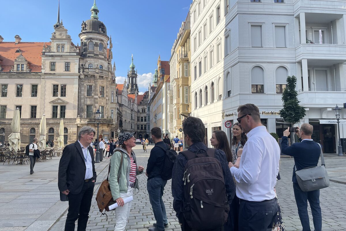 Mehrere Personen stehen während einer Stadtführung vor dem Dresdner Residenzschloss.