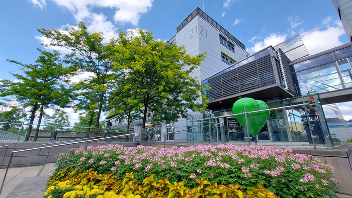 Eingangsbereich der Frauen- und Kinderklinik der Uniklinik mit Blumen, Treppen und einem grünen großen Herzen