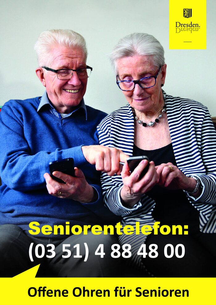 Mann und Frau mit grauen Haaren und Brille schauen auf ein Handy, dabei steht: Seniorentelefon: 03514884800 - Offene Ohren für Senioren