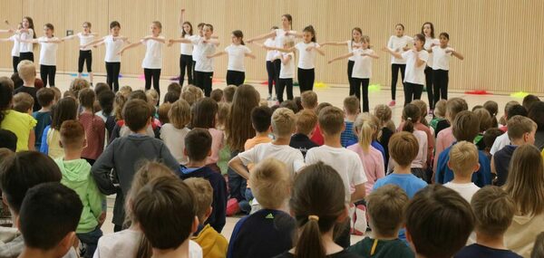 Tanzaufführung der Tanz-AG mit Kindern in weißen Shirts und schwarzen Hosen