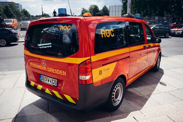 Roter Transporter mit Blaulicht und der Beschriftung "Feuerwehr Dresden"
