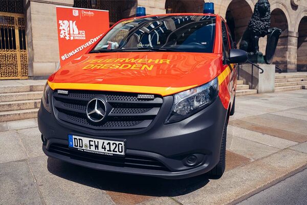 Roter Transporter von vorn mit Blaulicht und der Beschriftung "Feuerwehr Dresden"