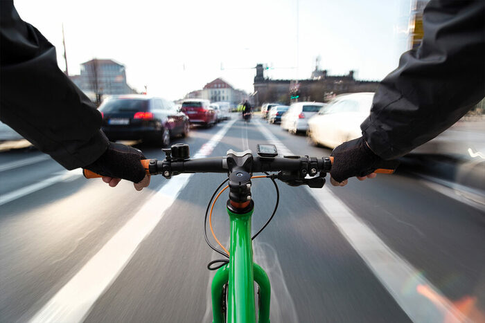 Radfahrer auf einem markierten Radstreifen in Mittellage zwischen zwei Fahrzeugspuren