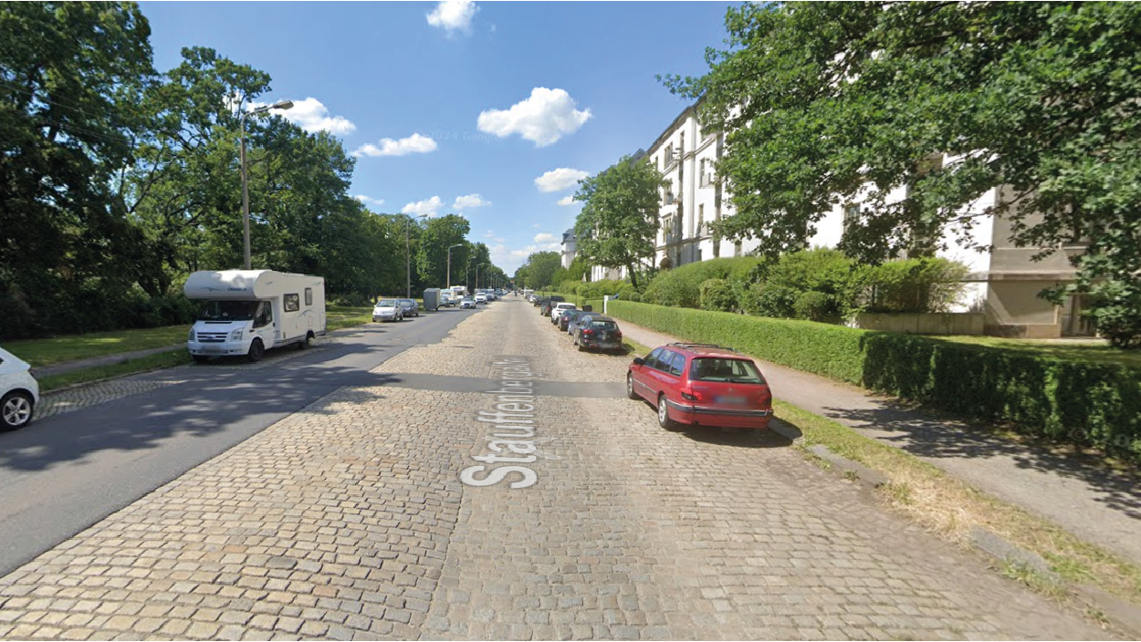 Straße mit Autos von Bäumen gesäumt