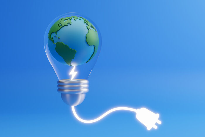 Symbolbild einer Glühbirne mit der Erde integriert und einem Stromkabel