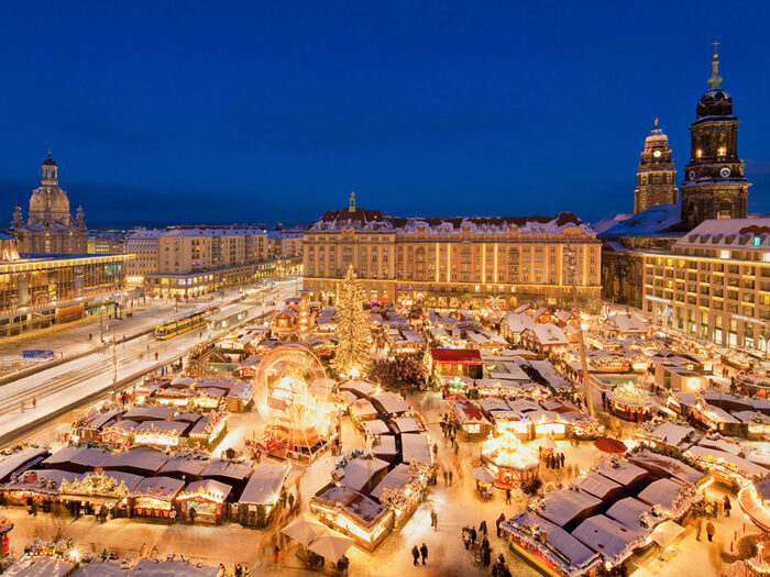 Blick auf festlichen Dresdner Striezelmarkt mit Kreuzkirche, Frauenkirche und Rathausturm.