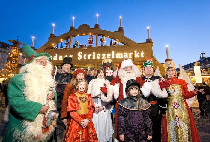 Taditionsfiguren des weihnachtlichen Bühnenprogramms vor dem Schwibbogen auf dem Striezelmarkt